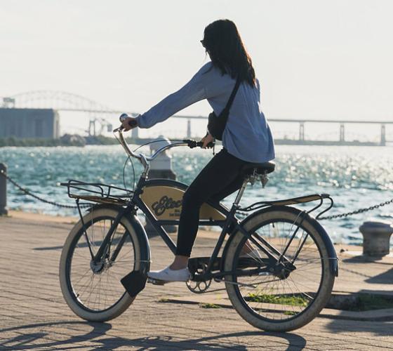 Young woman riding bike on waterfront.